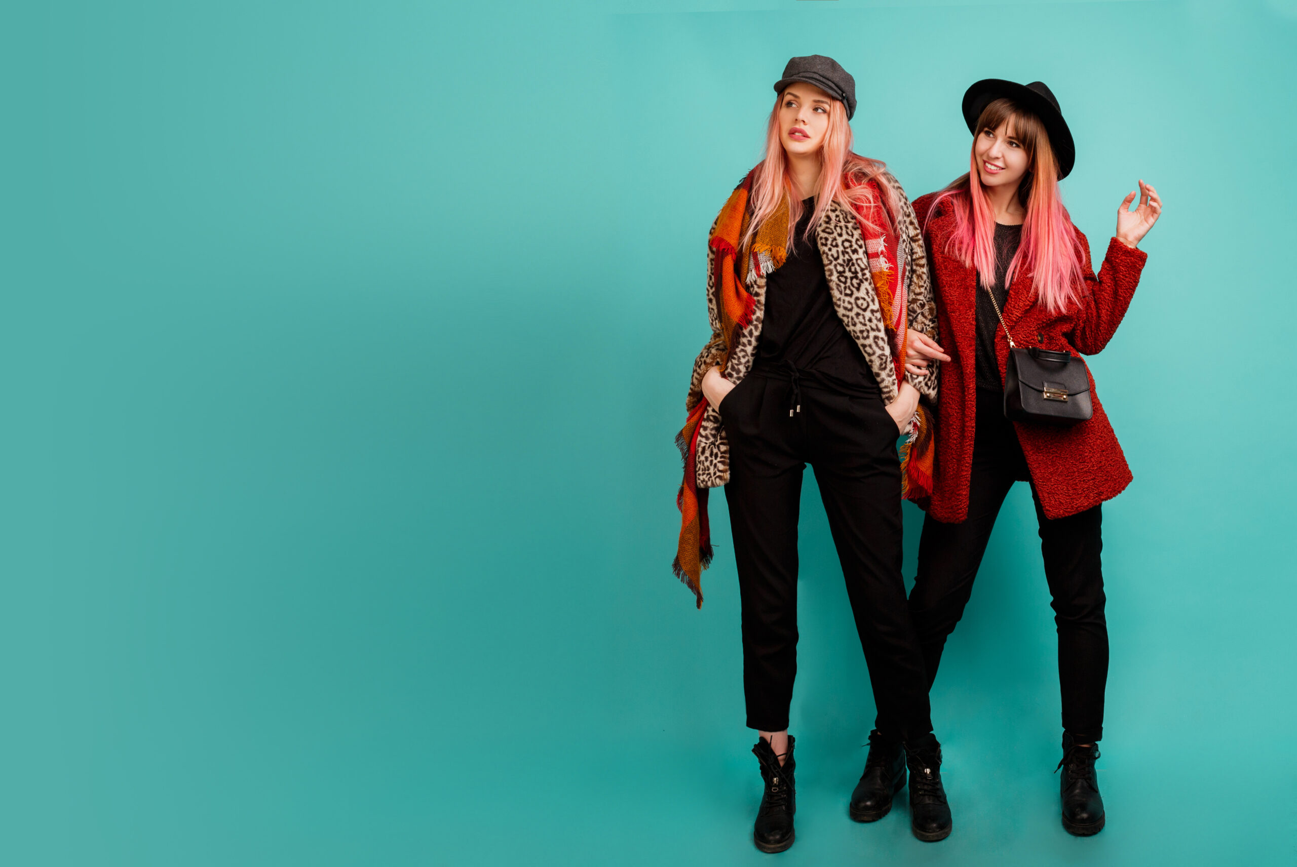 two-beautiful-women-stylish-faux-fur-coats-wool-scarf-posing-turquoise-wall